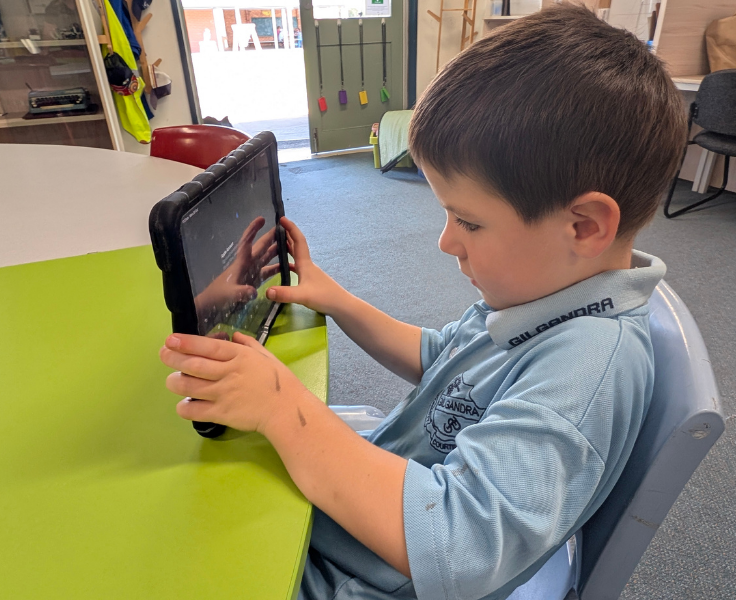 Kindergarten student using one of our iPads for learning