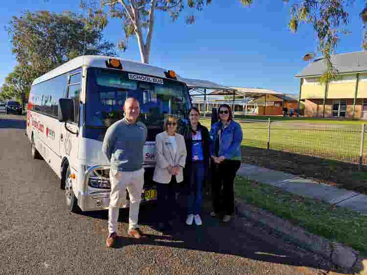 The Principal and 3 staff members standing in front of our new 22 seater bus