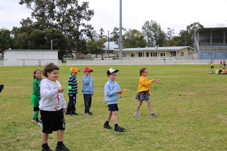 Students walking carefully with eggs on spoons in a race